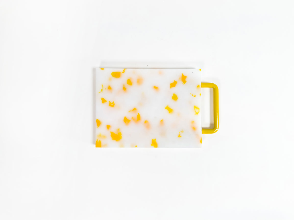Small yellow and white chopping board with metal handle