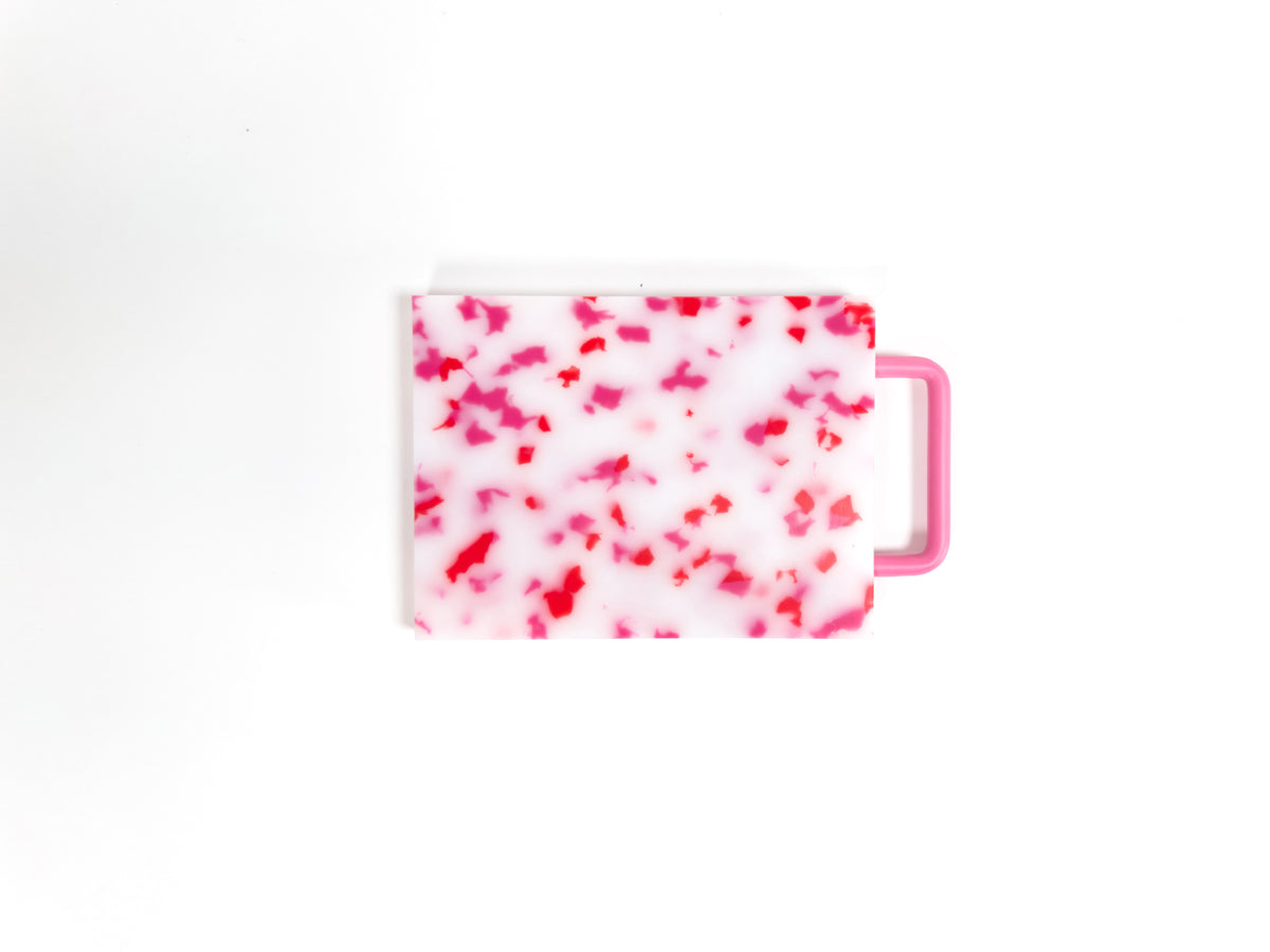 Small pink and white chopping board with metal handle