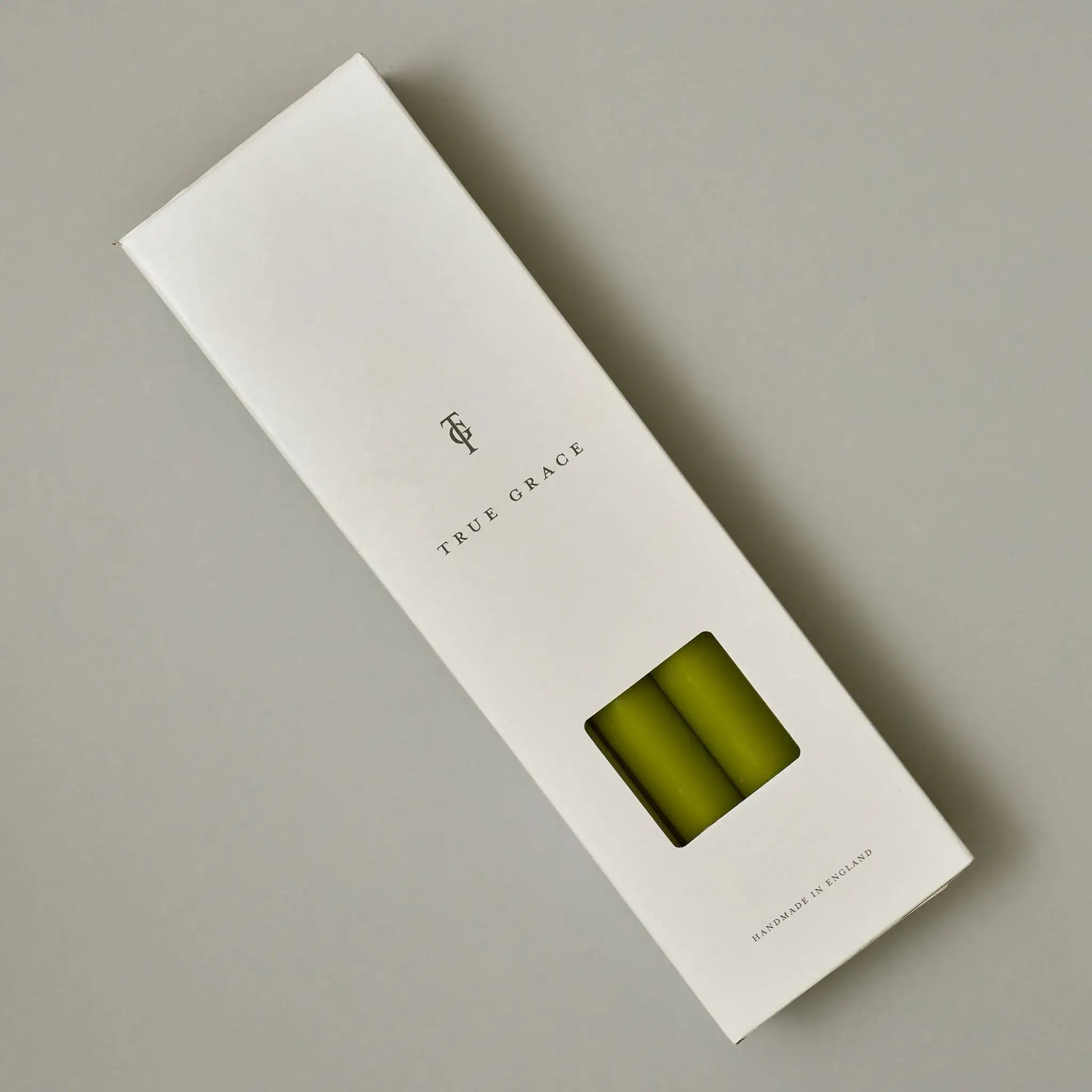 True Grace leaf green dinner candle shown lit