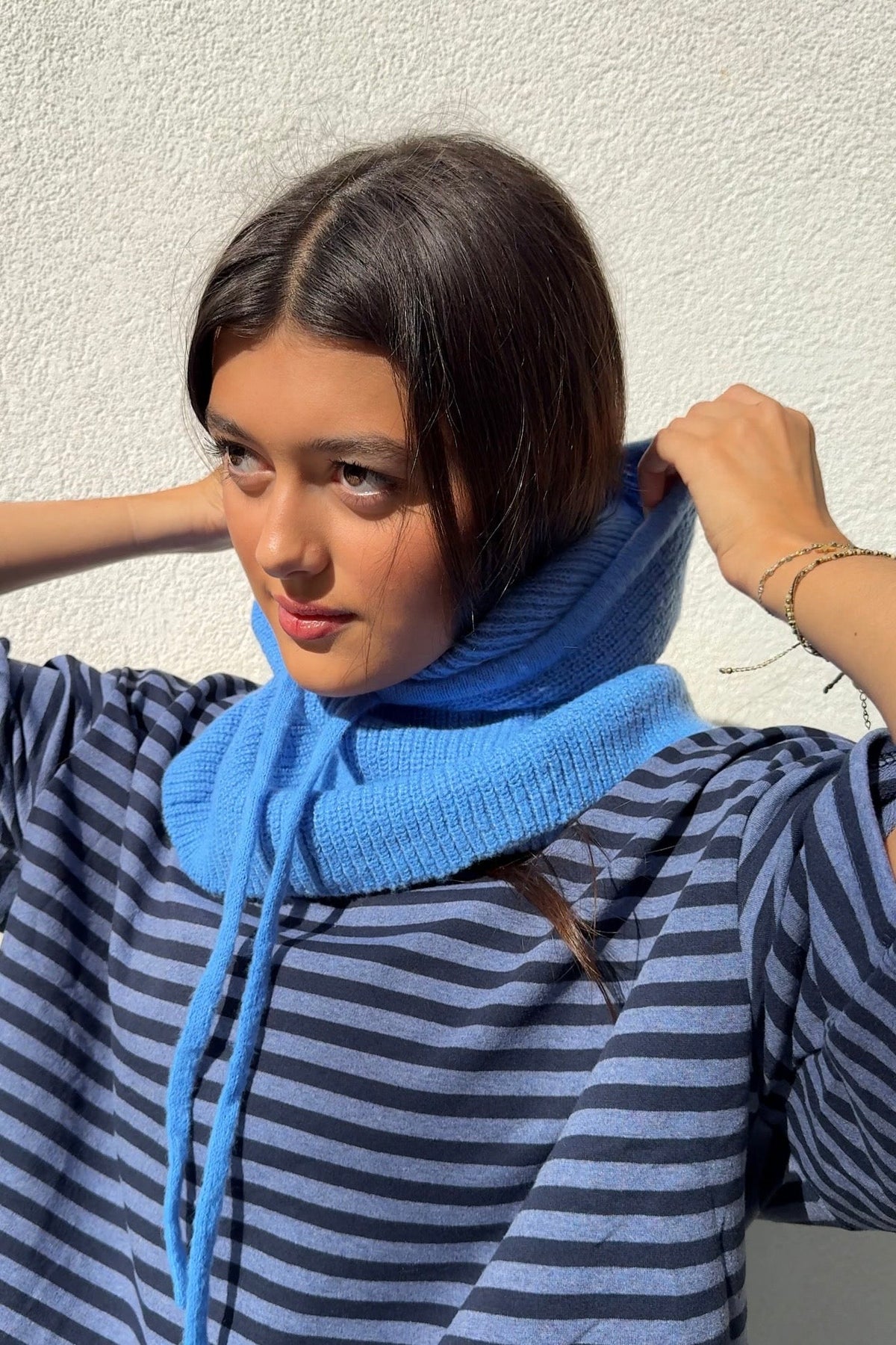 Cornflower blue knitted balaclava worn as a hood