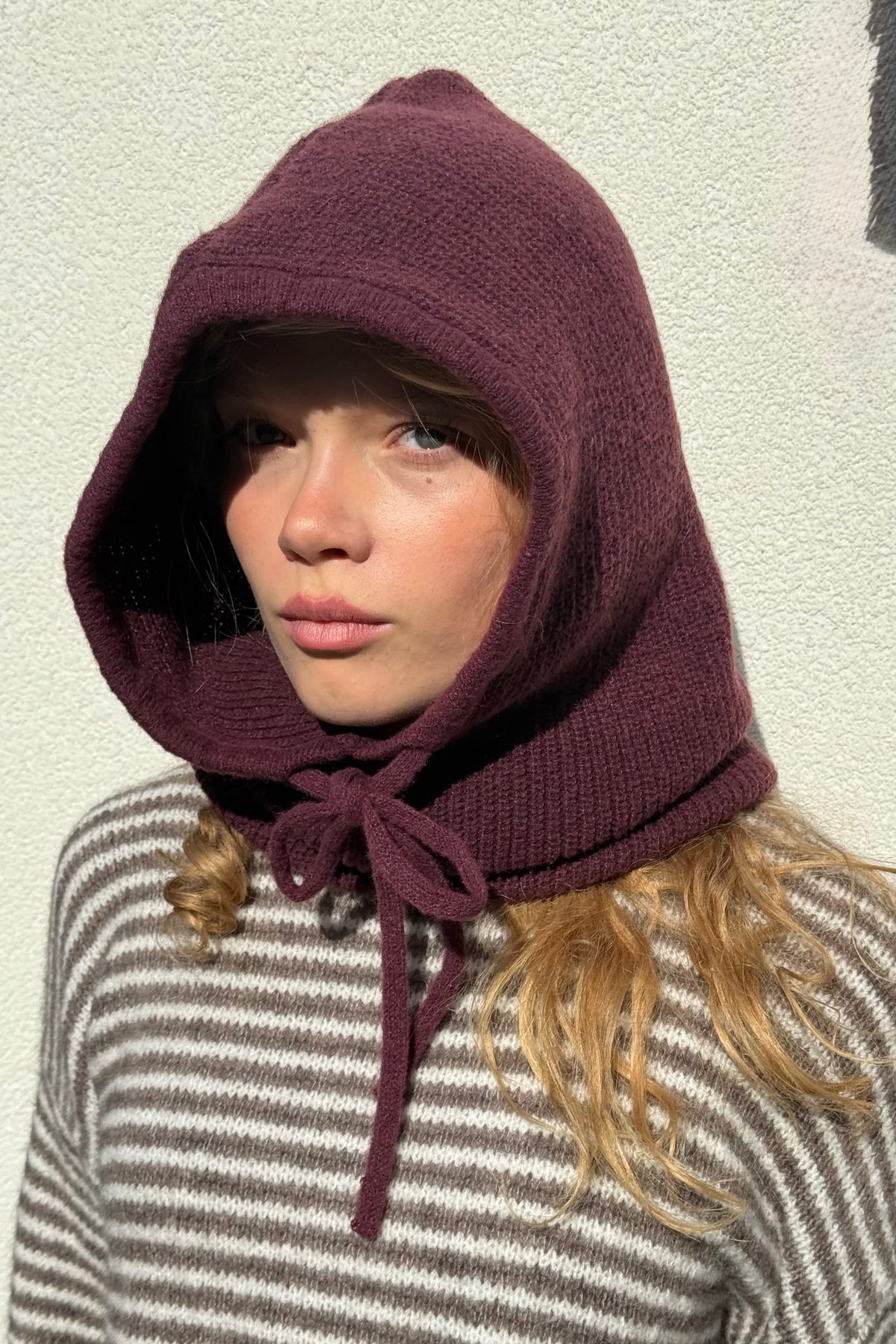 Burgundy knitted balaclava worn as a hood