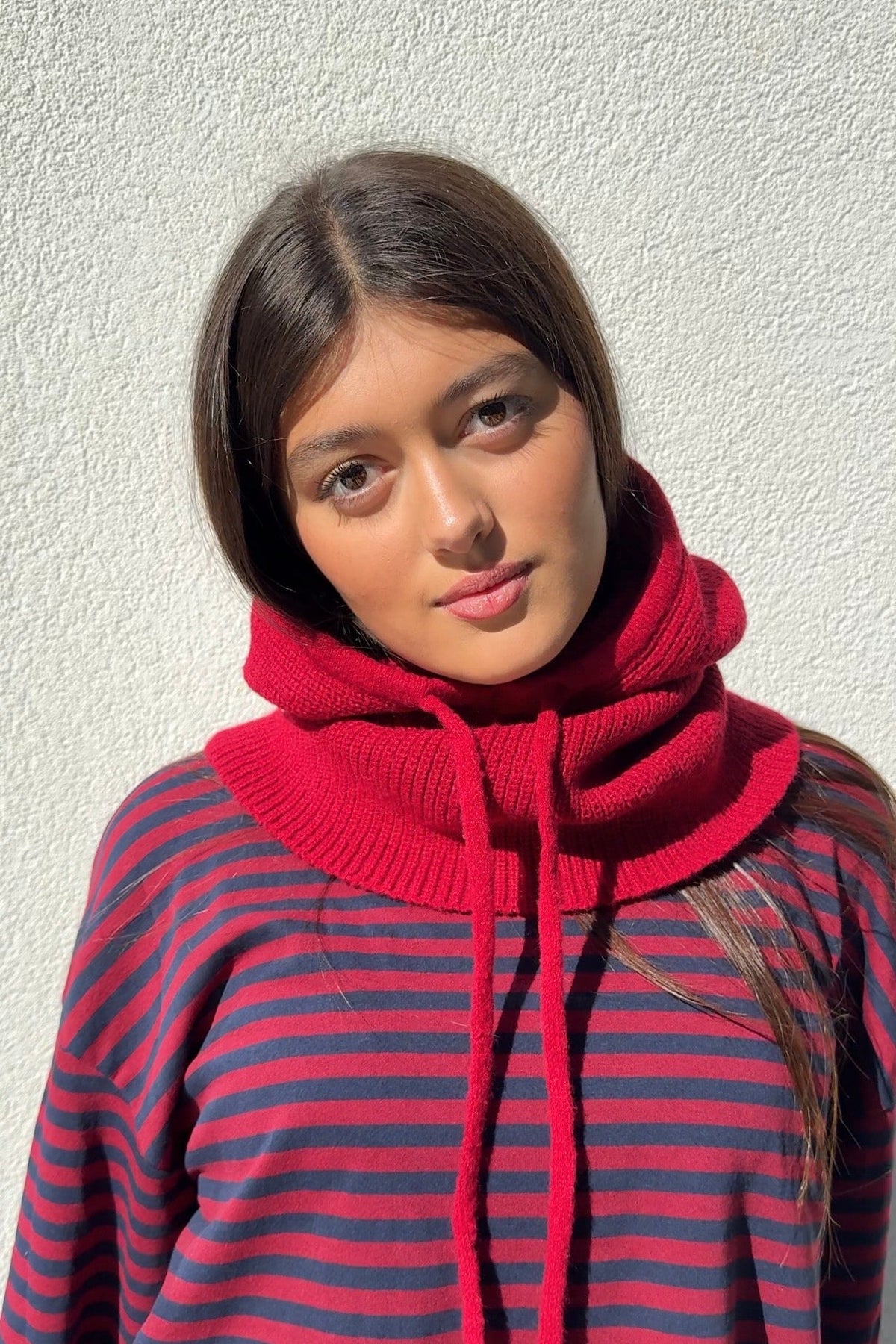 Red knitted balaclava worn as a hood