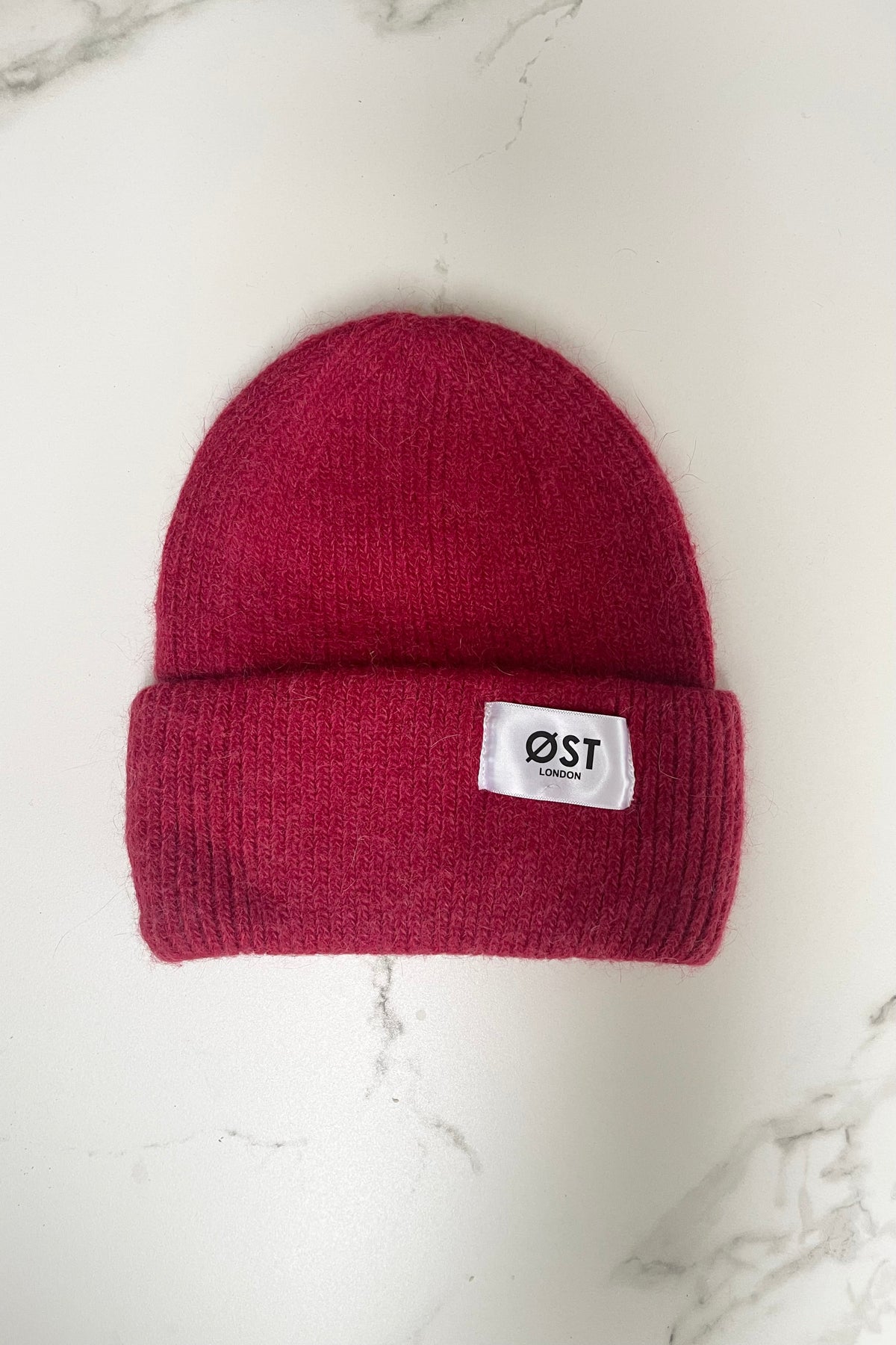 Dark red knitted beanie worn slouchy