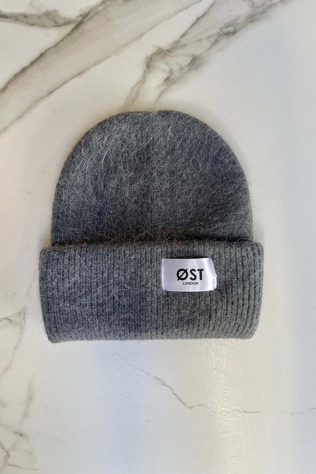 Dark grey knitted beanie worn slouchy
