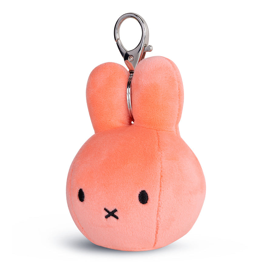 A small plush bunny keychain in a soft peach-pink color with embroidered black eyes and a stitched X mouth, attached to a silver metal clasp, on a clean white background.