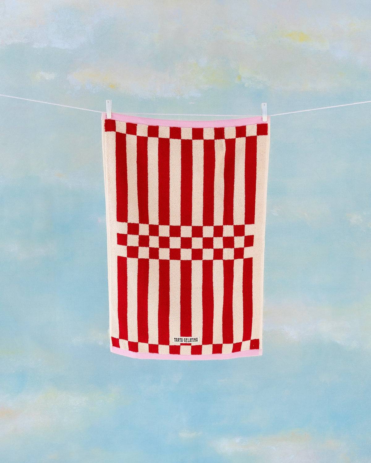 Clubhouse bath towel in red by Tarta Gelatina, hanging full length