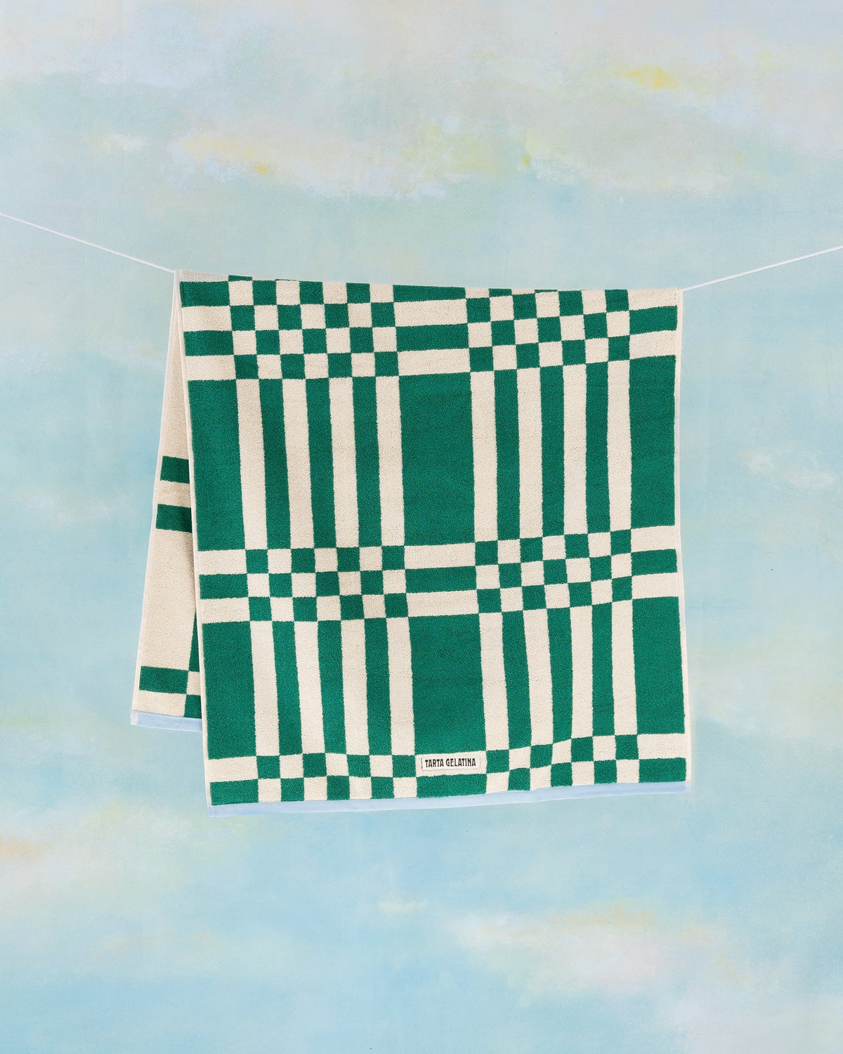 Marina bath towel in green by Tarta Gelatina, hanging full length