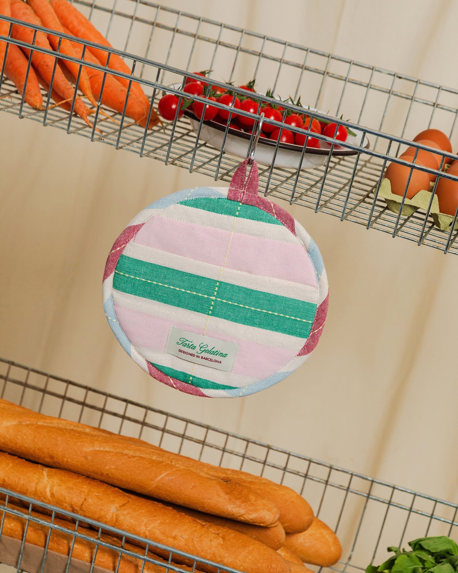 Striped round pot holder by Tarta Gelatina, hanging on kitchen wall