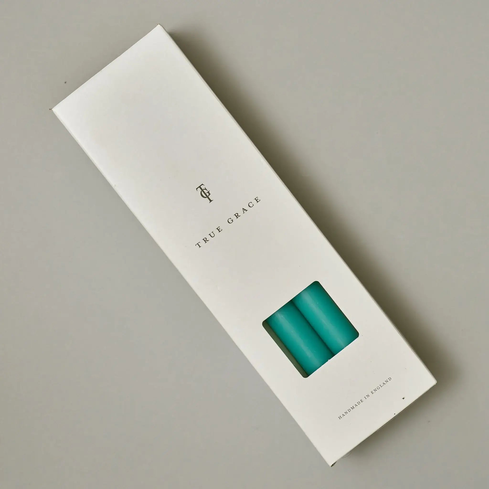 True Grace turquoise dinner candle shown lit