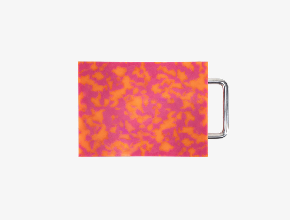 Small pink and orange chopping board with metal handle
