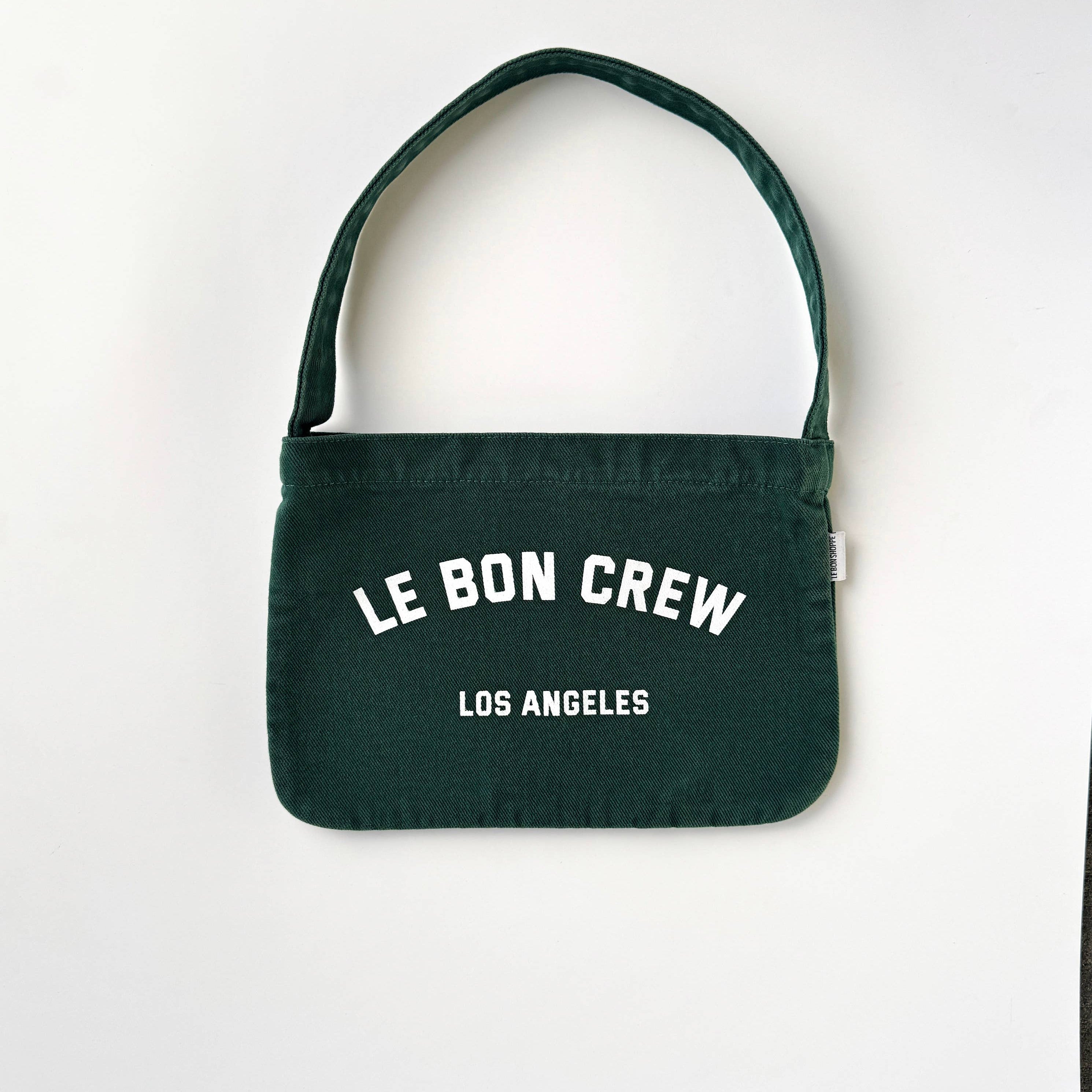 Green handbag with 'Le Bon Crew Los Angeles' text on a white background